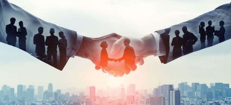 Business deal - two people shaking hands with a city in the background